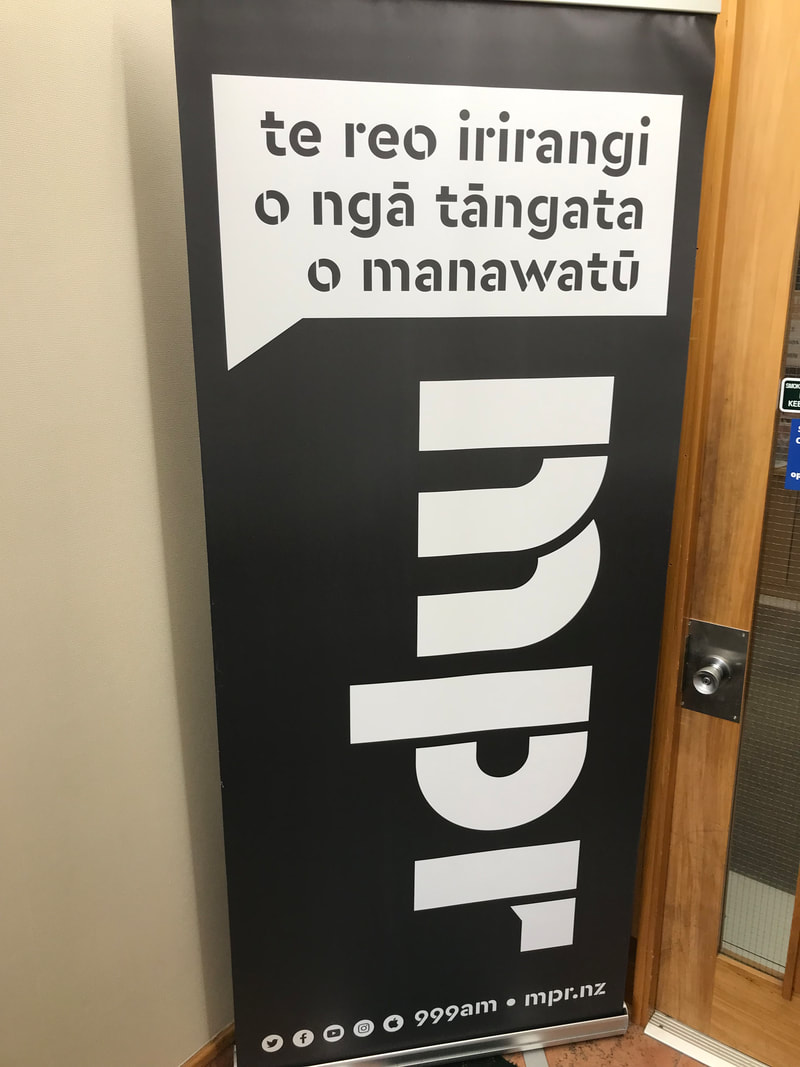 Picture of a black and white vertical banner for the community radio programme Manawatū People's Radio. It says, 