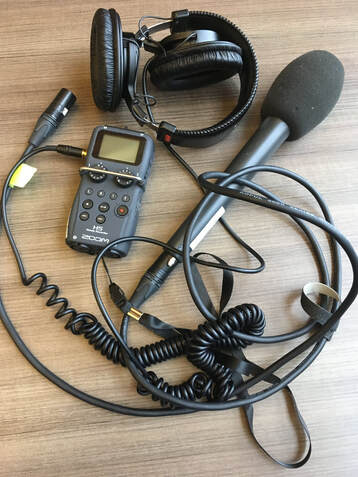 Handheld mic, digital recorder, over ear headphones, and cables for podcasting